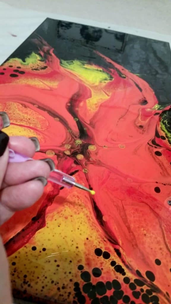 using dotting tools to add to acrylic pour painting
